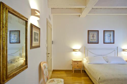 ジュリアノーヴァにあるL'Orso e L'Ape B&Bのベッドルーム1室(ベッド1台付)が備わります。壁に絵が飾られています。