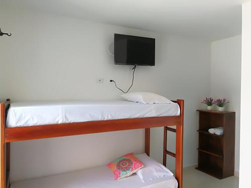 Pokój z 2 łóżkami piętrowymi i telewizorem z płaskim ekranem w obiekcie Miraluna Hotel Boutique w mieście Coveñas