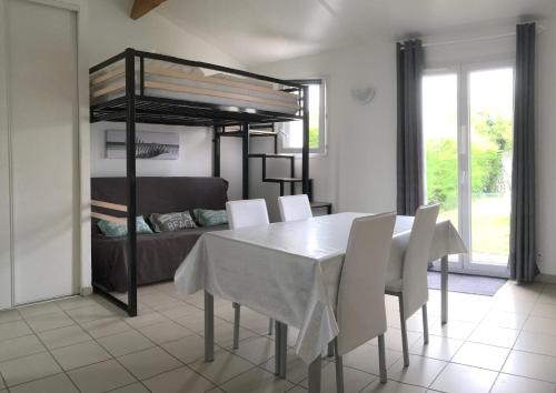 a dining room with a table and a bunk bed at Escale à l'île d'Oléron in Le Château-dʼOléron