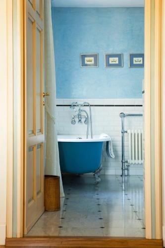 a blue and white bathroom with a tub in it at Villa Tiboldi in Canale