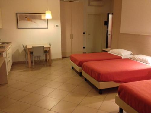 Habitación de hotel con 2 camas y mesa en Bassini Residence, en Bolonia