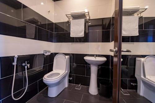 a bathroom with a toilet and a sink at Hamilton Hotel Kajang in Kajang