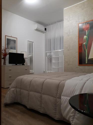 - une chambre avec un grand lit et une table dans l'établissement La Casetta di Pat, à Palerme