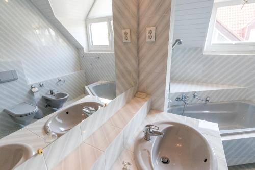 a bathroom with two sinks and a tub and a toilet at Haus Sonnenhof in Siófok