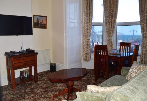 a living room with a couch and a table at The Town House in Douglas