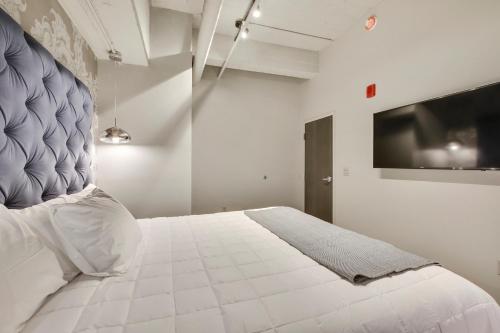 a bedroom with a large white bed and a tv at Etage Executive Living in Pittsburgh