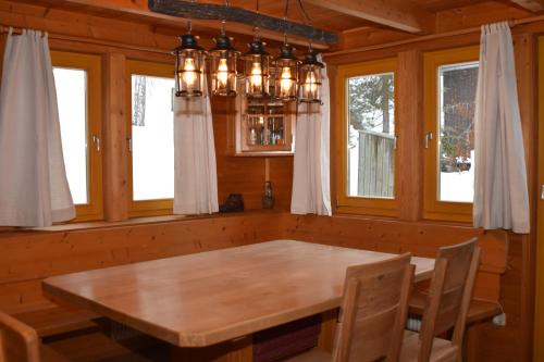 a dining room with a wooden table and a chandelier at Verditzhütte in Verditz