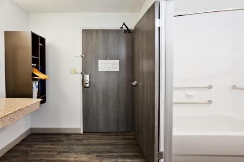 a bathroom with a wooden door in a room at Best Western Montgomery I-85 North in Montgomery