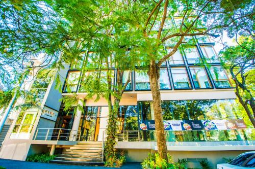 un bâtiment avec des arbres devant lui dans l'établissement Five Hotel & Residences, à Asuncion