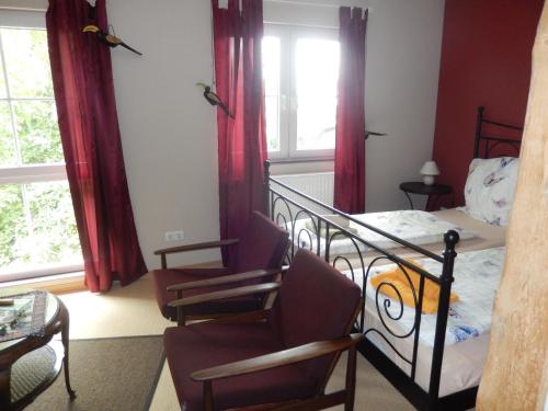 Holtsee的住宿－Eiderhufe，一间卧室配有一张床、一把椅子和窗户。
