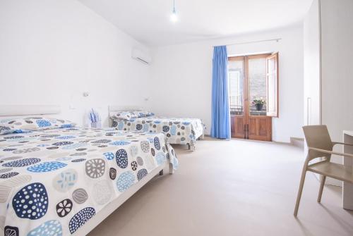 a bedroom with two beds and a table and chairs at Le Nereidi in Castellammare del Golfo