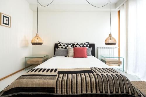 ein Schlafzimmer mit einem großen Bett und zwei Lampen in der Unterkunft By the Sea Apartment • Terrace · Wifi · Netflix in Matosinhos