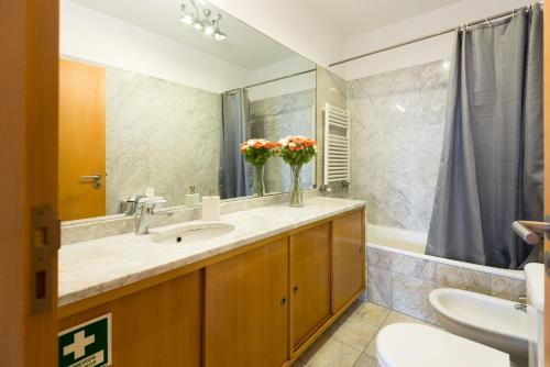 ein Bad mit einem Waschbecken und einem Spiegel in der Unterkunft By the Sea Apartment • Terrace · Wifi · Netflix in Matosinhos