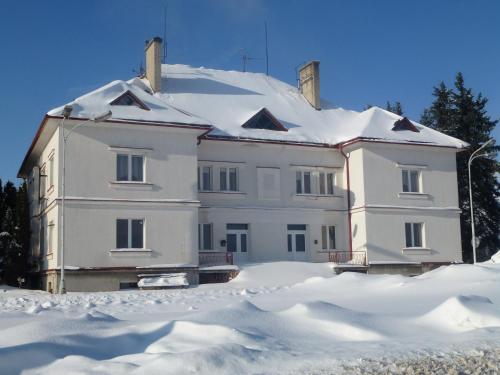 a large white house with snow on top of it at Byczy Rog noclehy na hranici in Králíky