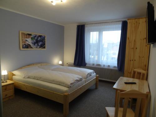1 dormitorio con cama, ventana y mesa en Nordwaldfarm en Waidhofen an der Thaya