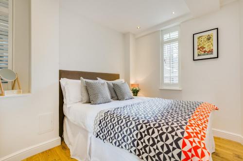 a white bedroom with a large bed in it at Nell Gwynn Chelsea Accommodation in London