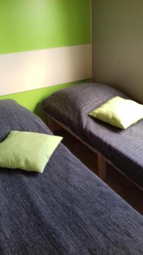 Habitación con 2 camas con sábanas azules y almohadas amarillas. en Camping " Le grun de Chignore", en Vollore-Ville