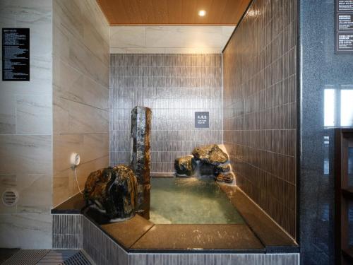 a bathroom with a bath tub with a fountain at Dormy Inn Hon-Hachinohe in Hachinohe