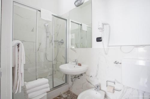a white bathroom with a sink and a shower at Boutique Hotel Liberty 1904 in Bologna