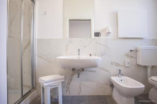 a white bathroom with a sink and a toilet at Boutique Hotel Liberty 1904 in Bologna