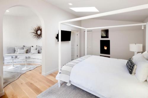 a white bedroom with a bed and a living room at Rockhouse Suites in Healdsburg