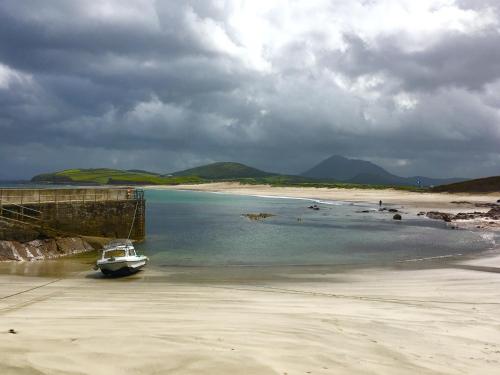 a small boat in the water on a beach at The Garden Room at Sleepy Hollow in Louisburgh