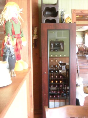 a shelf with a cabinet of wine bottles at Auberge Au Soleil Levant in Piopolis
