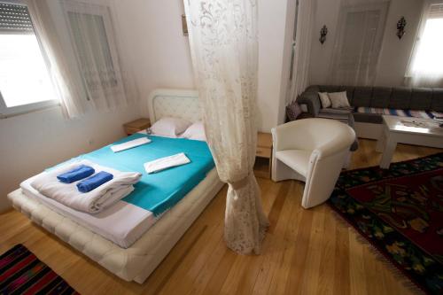 a small bedroom with a bed and a chair at Hotel & Rooms Lombrelle in Mostar