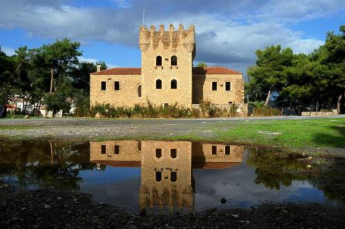 an old building with its reflection in a puddle at Aktaion City Hotel in Gythio