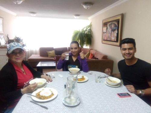 a group of people sitting around a table eating food at La Casa De La Nonna in Quito