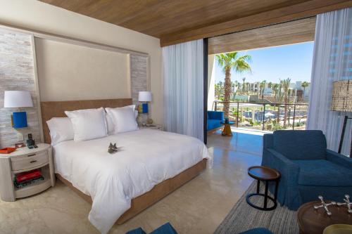 um quarto com uma cama grande e uma cadeira azul em Chileno Bay Resort & Residences, Auberge Collection em Cabo San Lucas