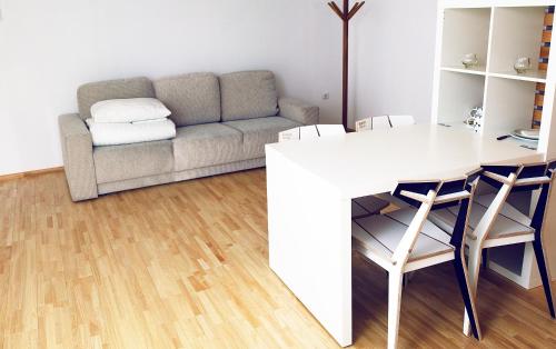a living room with a couch and a table and chairs at Draugų namai in Druskininkai