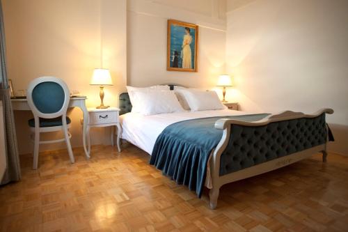 a bedroom with a bed and a chair and two lamps at ApartHotel Vila Minka in Ljubljana