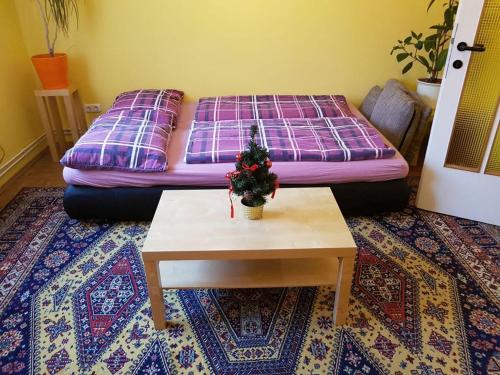 ein Wohnzimmer mit einem Bett und einem Tisch mit einer Pflanze in der Unterkunft Garden Apartment Donau-City (P&R) in Wien