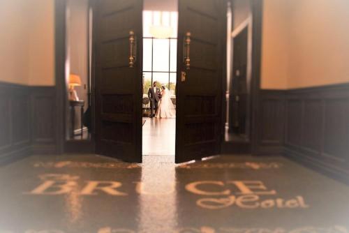 a bride and groom walking through the doors of a room at The Bruce Hotel in Stratford