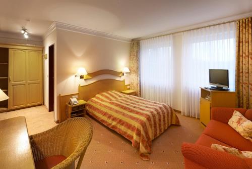 una camera d'albergo con letto e TV di Hotel Kastanienhof a Bad Münder am Deister