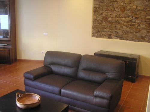 a living room with a leather couch and a table at Moradia Rossio,11 in Odeceixe