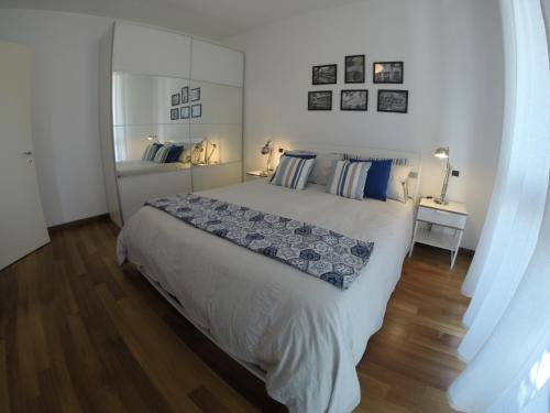 una camera da letto bianca con un letto grande e uno specchio di Casa Lorelei a Sestri Levante