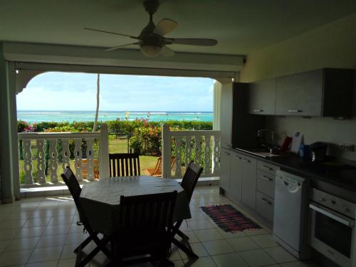 uma cozinha com uma mesa e vista para o oceano em Savannah Guadeloupe em Saint-François