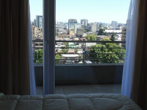 a view of a city from a window with a couch at Departamento Concepción Centro in Concepción