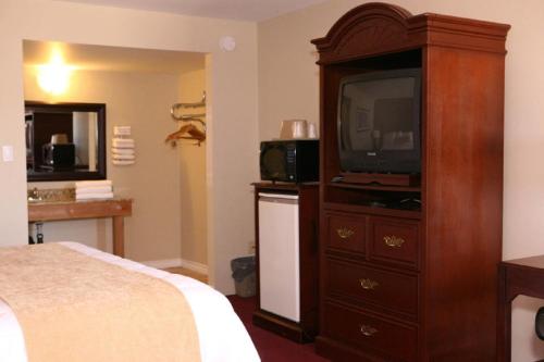 una camera d'albergo con letto e televisore in un comò di Saxony Motel a Chatham