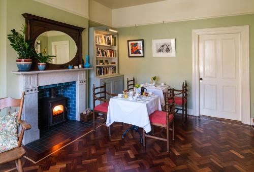 a dining room with a table and a fireplace at Ravenhill House in Belfast