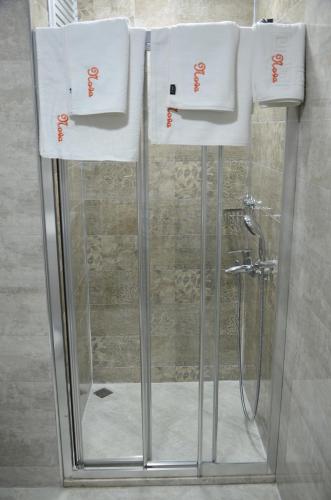 a shower with white towels on top of it at Nova Citrus Otel in Siğacık