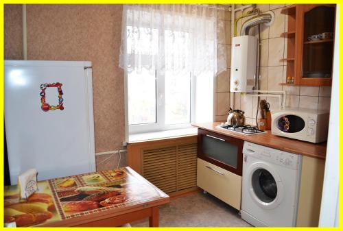 a kitchen with a white refrigerator and a microwave at Уютная 1-квартира в центре города in Shakhty