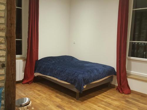 ディエップにあるGALION - BERIGNYの赤いカーテンが備わるドミトリールームの小さなベッド1台分です。