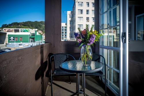 a vase of flowers sitting on a table on a balcony at Courtenay Village in Wellington