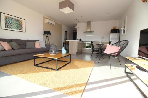 a living room with a couch and a table at Le Clos de la Montagnette - Maison avec parking et jardin in LʼIsle-sur-la-Sorgue