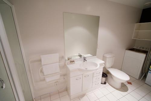 a white bathroom with a toilet and a sink at Willis Village in Wellington