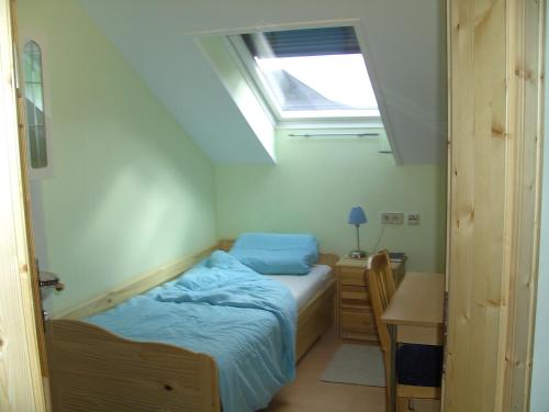 a bedroom with a bed and a desk and a window at Haus Bergblick in Maiersdorf