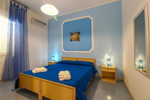 a blue bedroom with a bed with towels on it at Villa Anastasia-Lampedusa in Lampedusa
